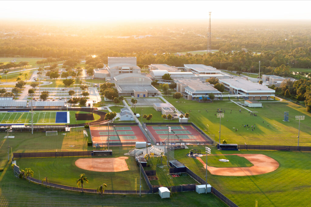 Aerial view of high school open air sports facilities in Florida. American football stadium, tennis court and baseball diamond sport infrastructure. Aerial view of high school open air sports facilities in Florida. American football stadium, tennis court and baseball diamon